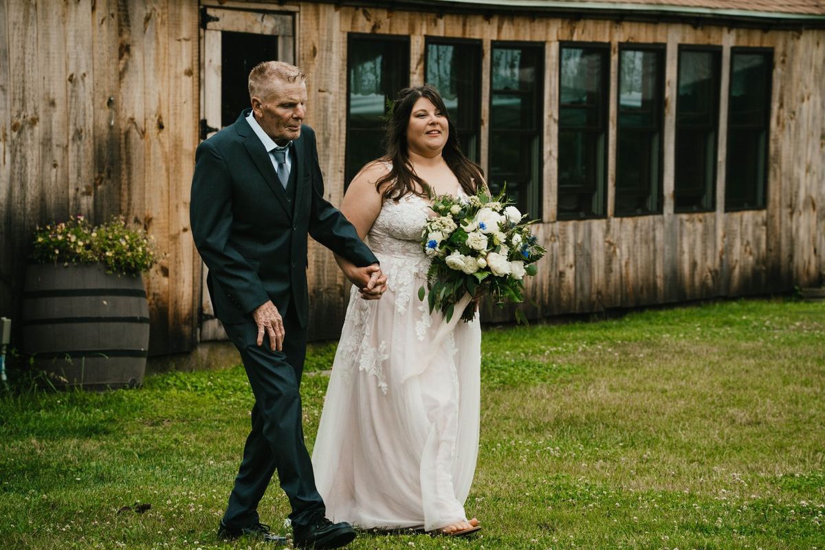 Ashley walks down the outdoor aisle with a loved one