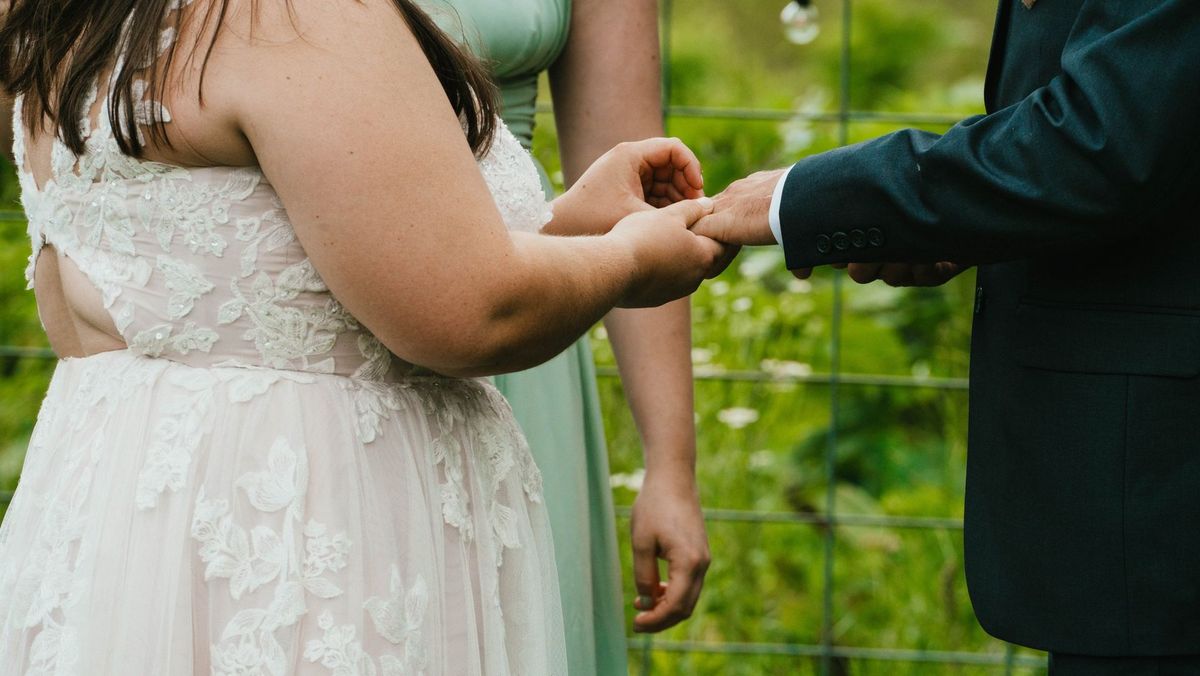 A close view of Ashley and Anthony holding hands during the ceremony