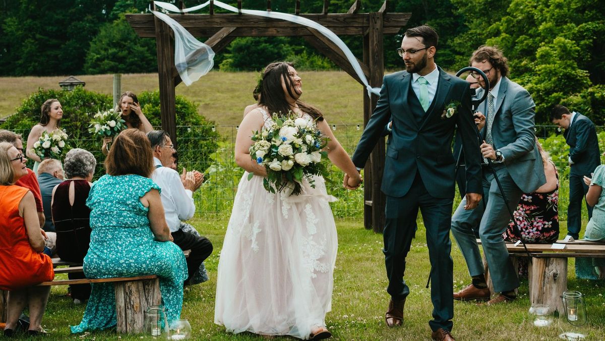 Ashley and Anthony walk away from their ceremony holding hands