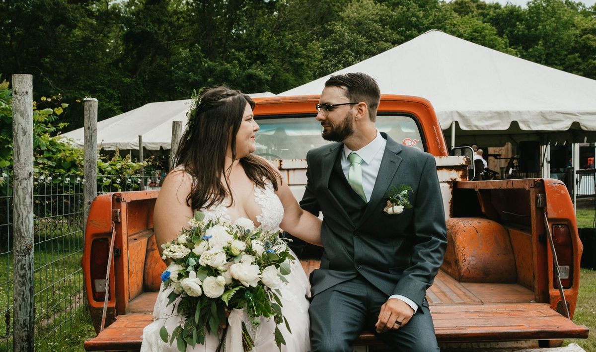 Ashley and Anthony sit together on the orange truck’s tailgate