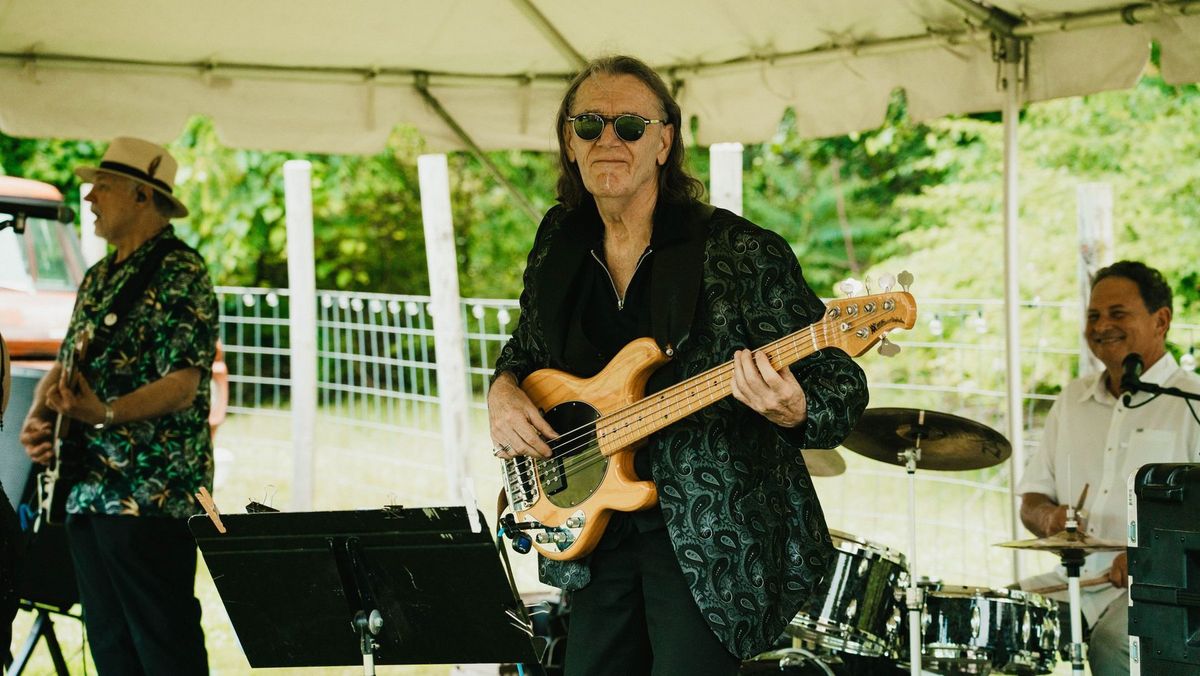 A musician plays bass beneath the reception tent