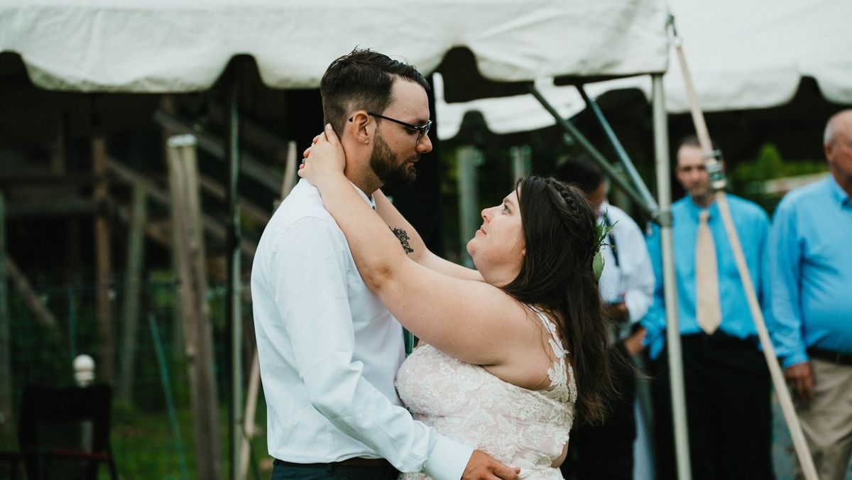 Ashley and Anthony dance together beside the reception tent