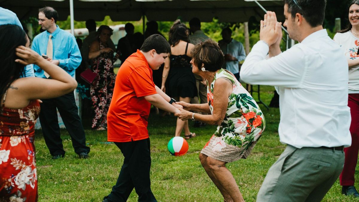 Wedding guests dance together on the lawn