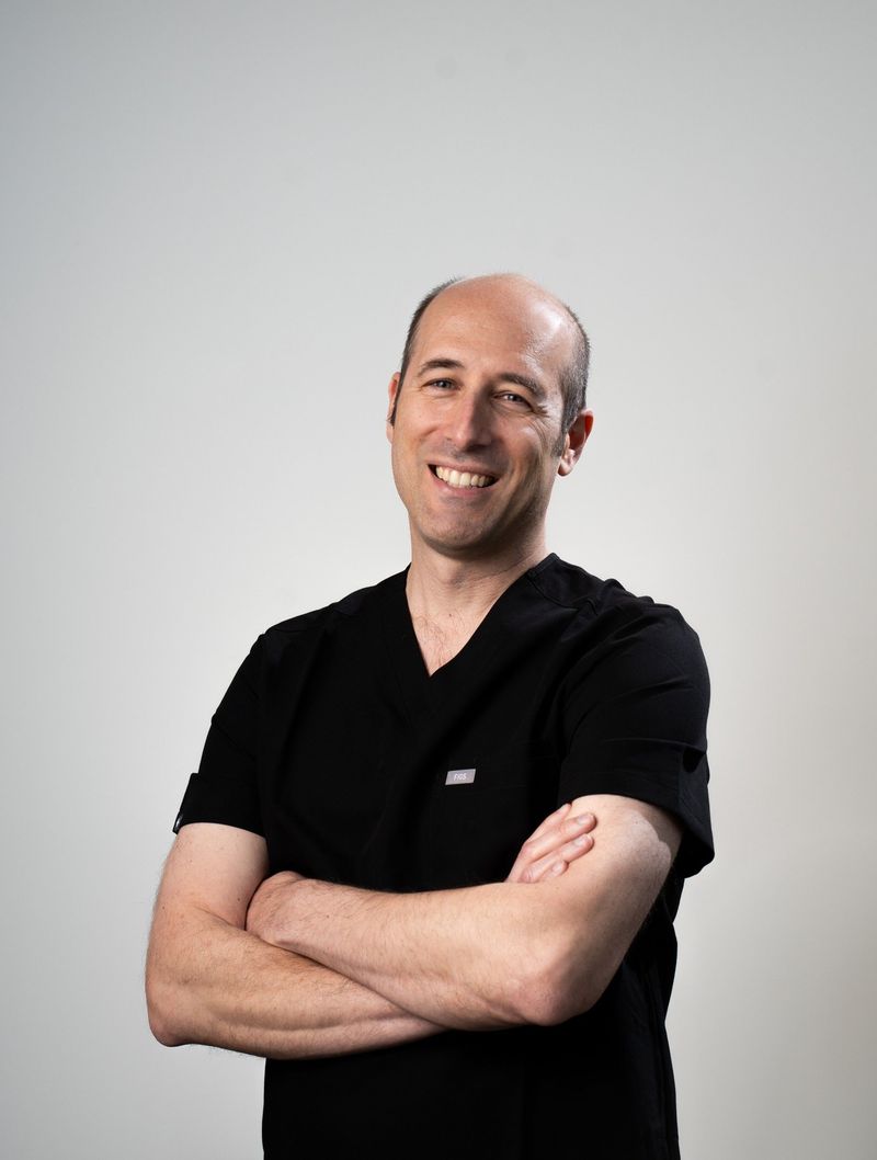Smiling BPS Periodontics team member with arms crossed in an individual portrait