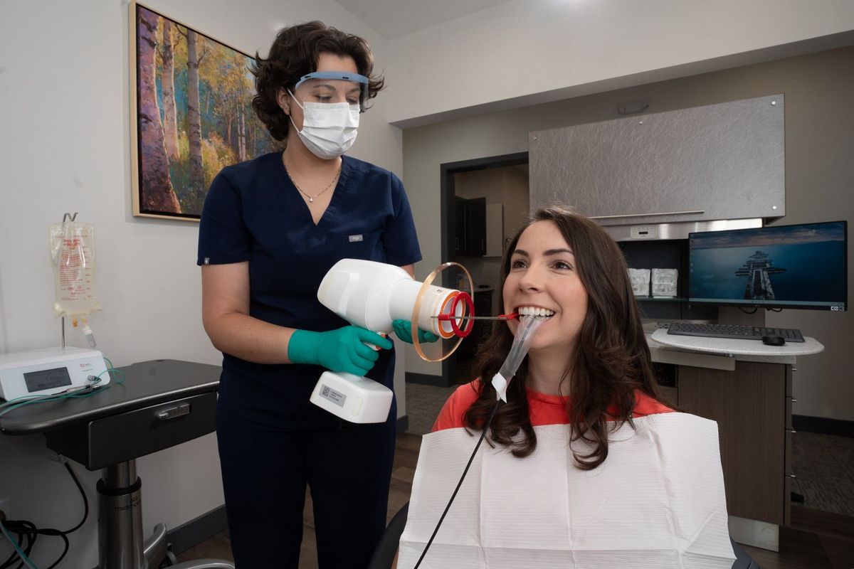 BPS Periodontics clinical scene with handheld dental equipment in use