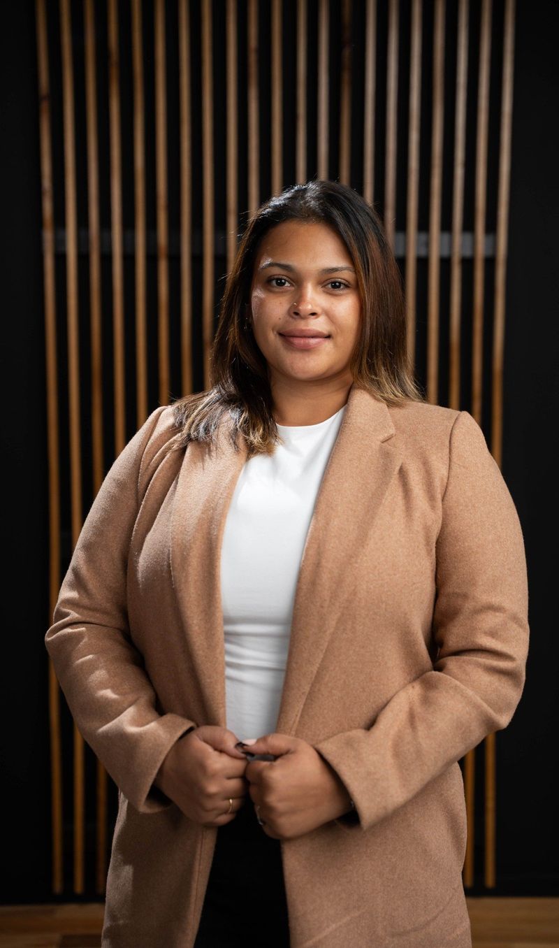 Brooke Team member in a tan jacket before the shared portrait background