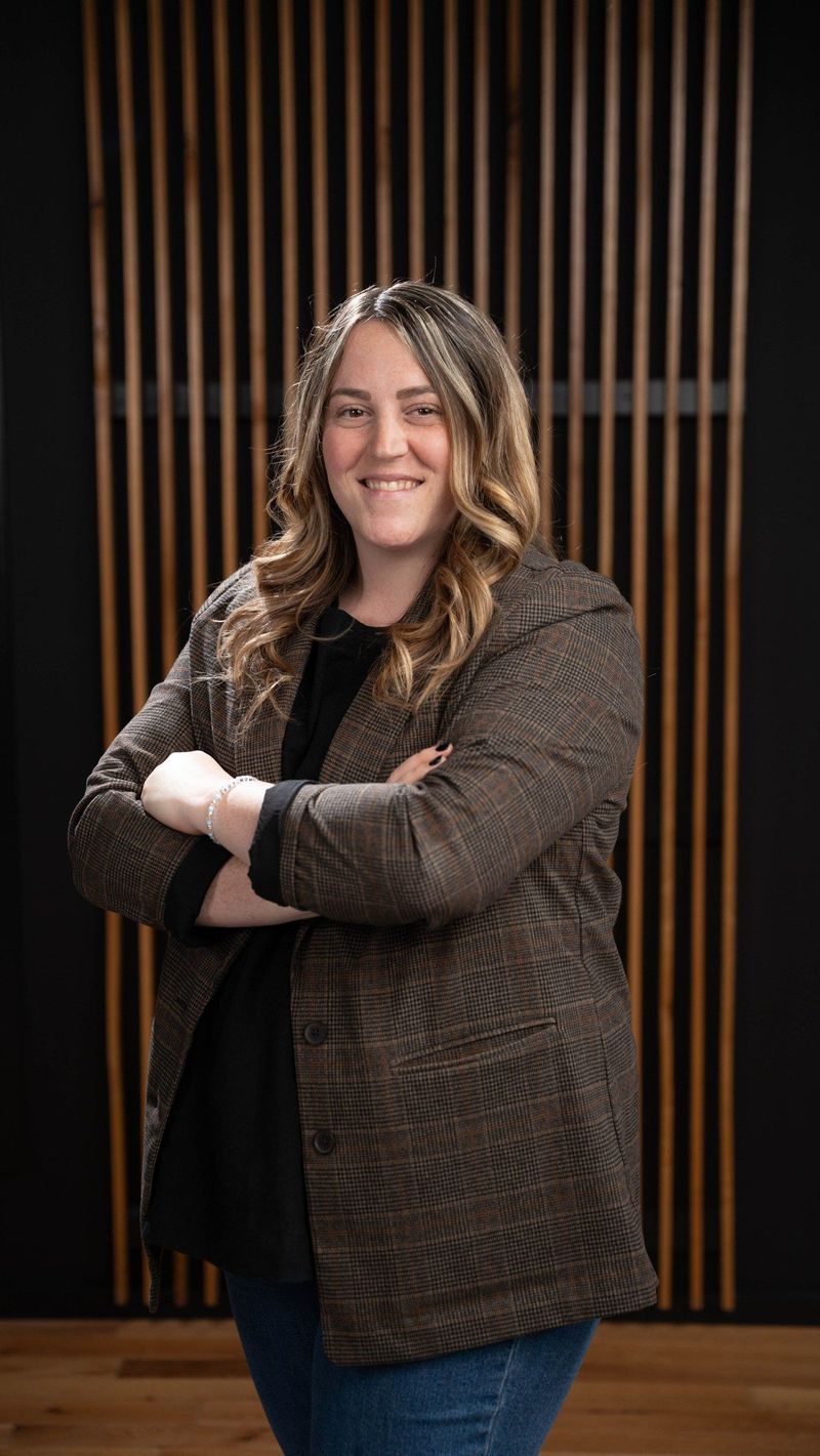 Brooke Team member in a checked jacket with arms folded