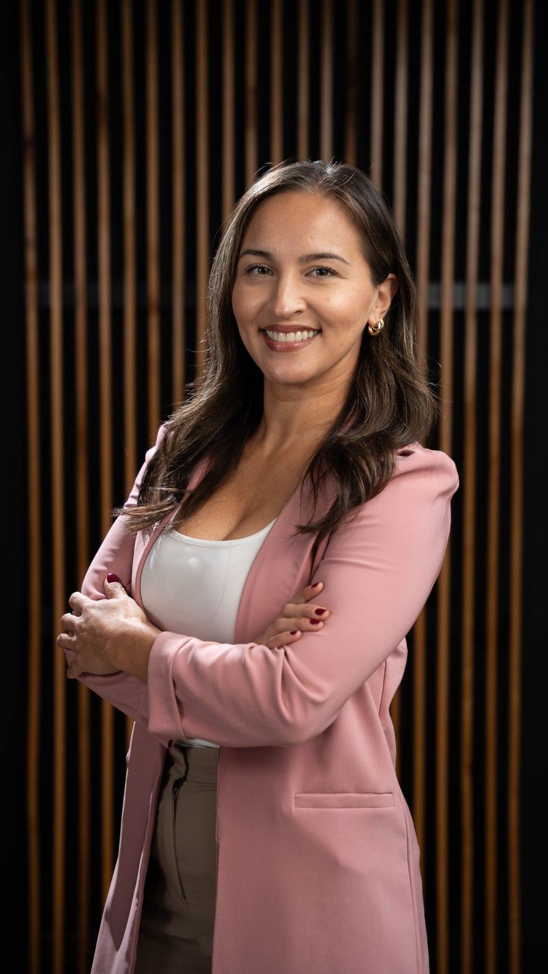 An alternate portrait of a Brooke Team member in a pink jacket with arms folded