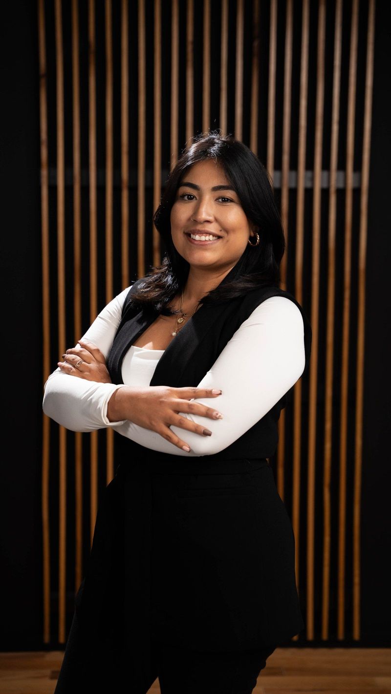 Brooke Team member in a white top and black vest with arms folded