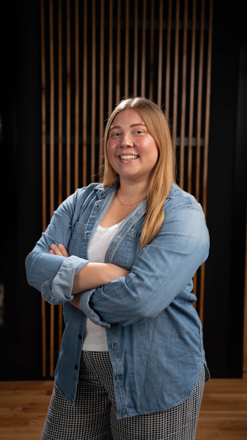 Brooke Team member in a denim shirt with arms folded