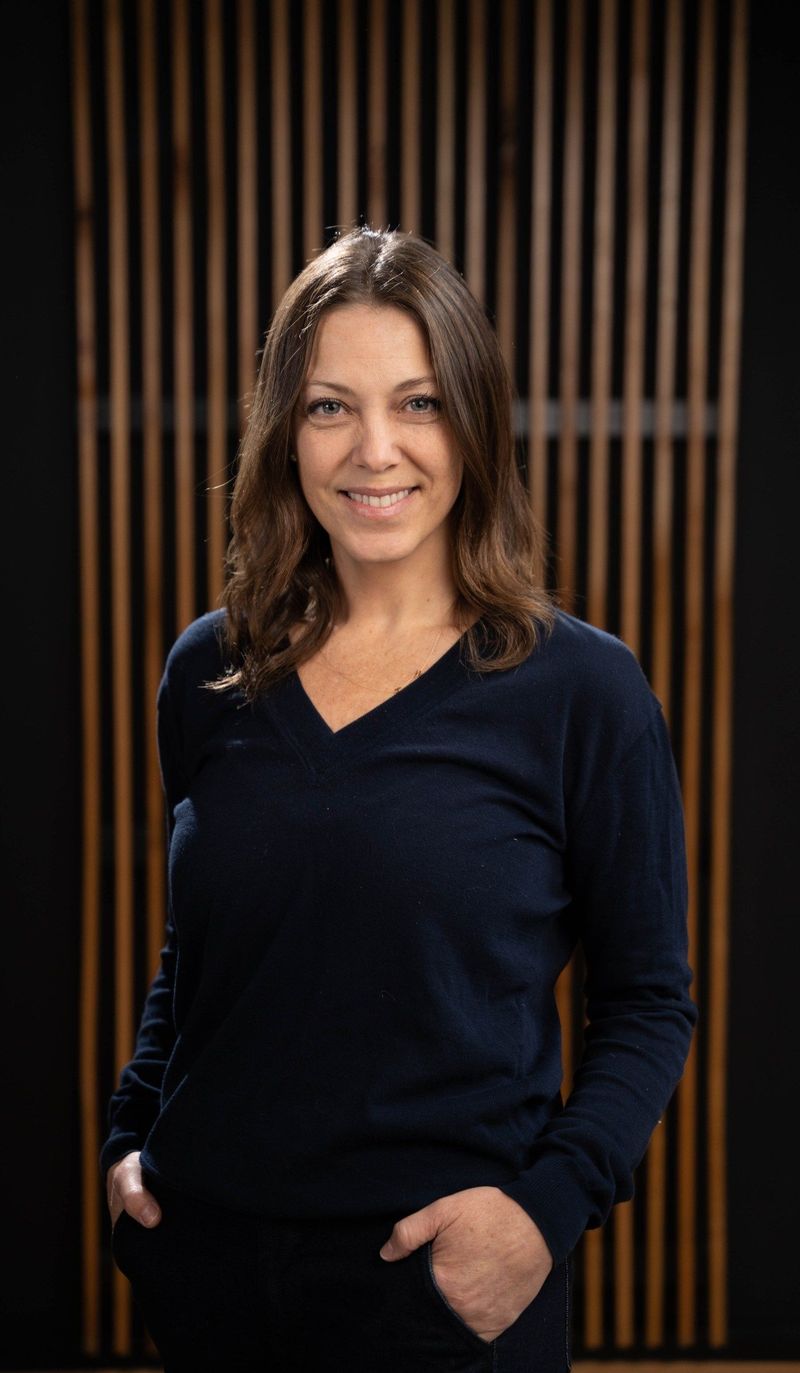 Brooke Team member in a navy blouse before the shared portrait background