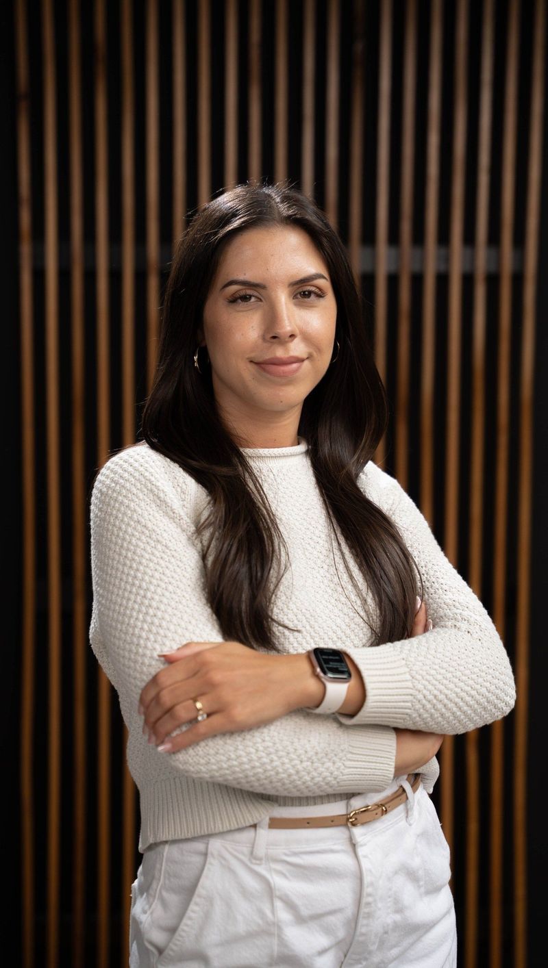 Brooke Team member in a cream top and white trousers with arms folded