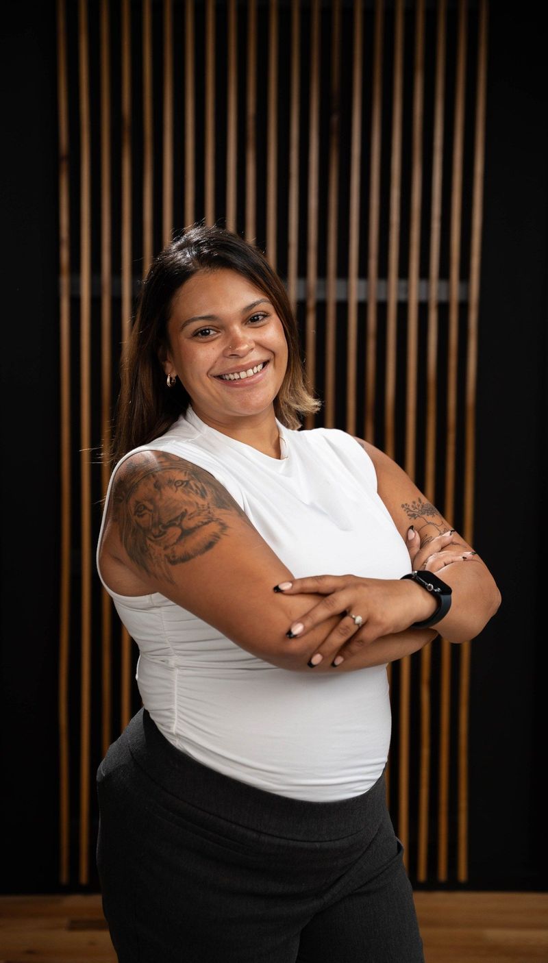 Brooke Team member in a sleeveless white top with arms folded