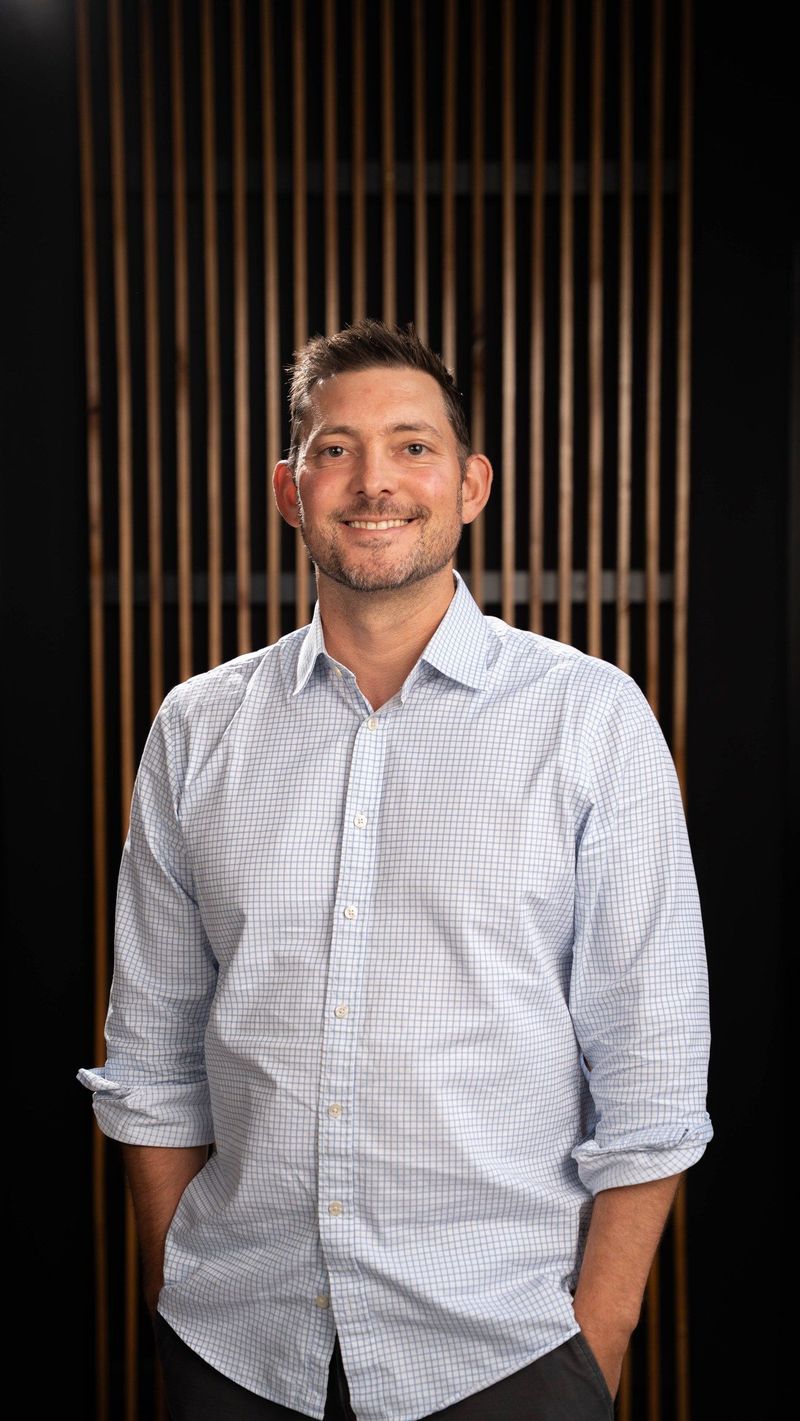 Brooke Team member in a pale blue shirt before the shared portrait background