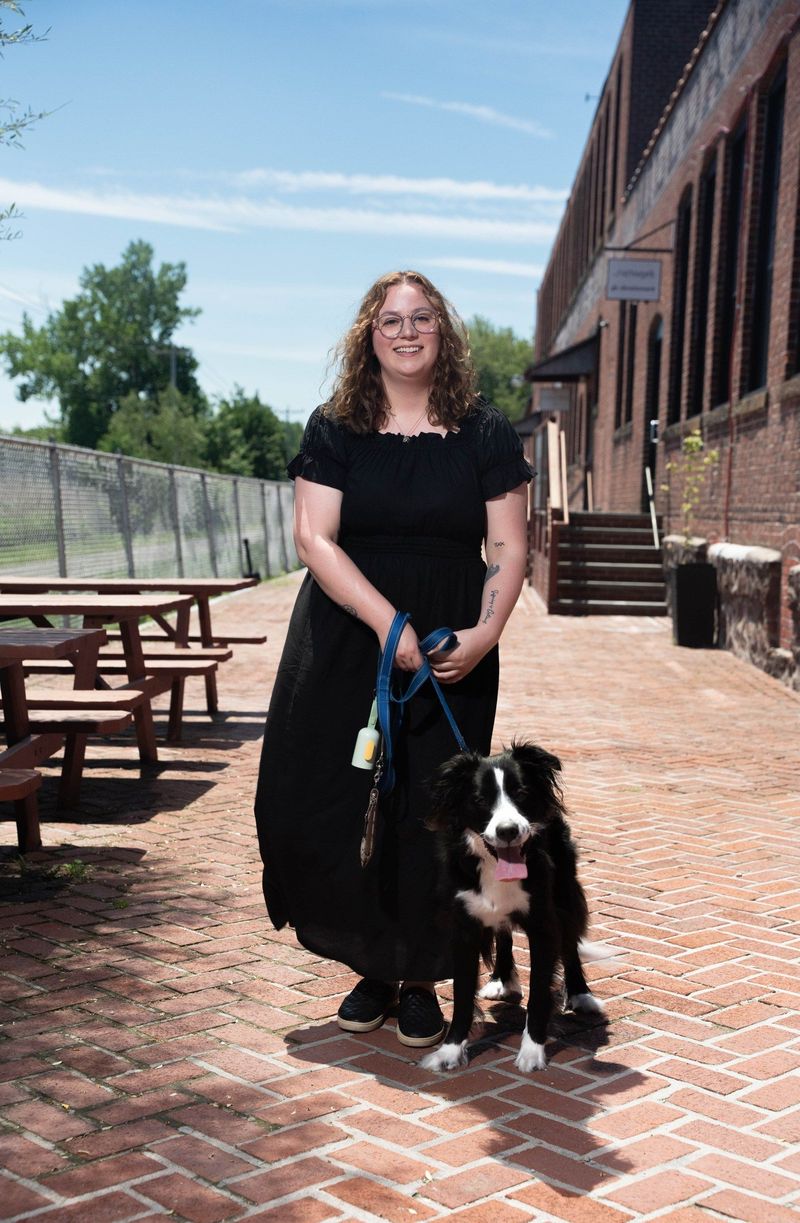 Brooke Team recruit stands with her dog on a brick walkway