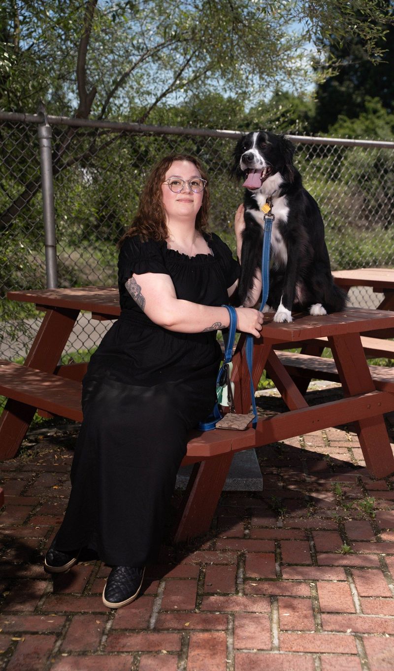 Brooke Team recruit poses beside her dog at an outdoor picnic table