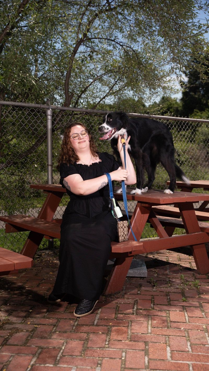 Brooke Team recruit shares a playful moment with her dog at a picnic table