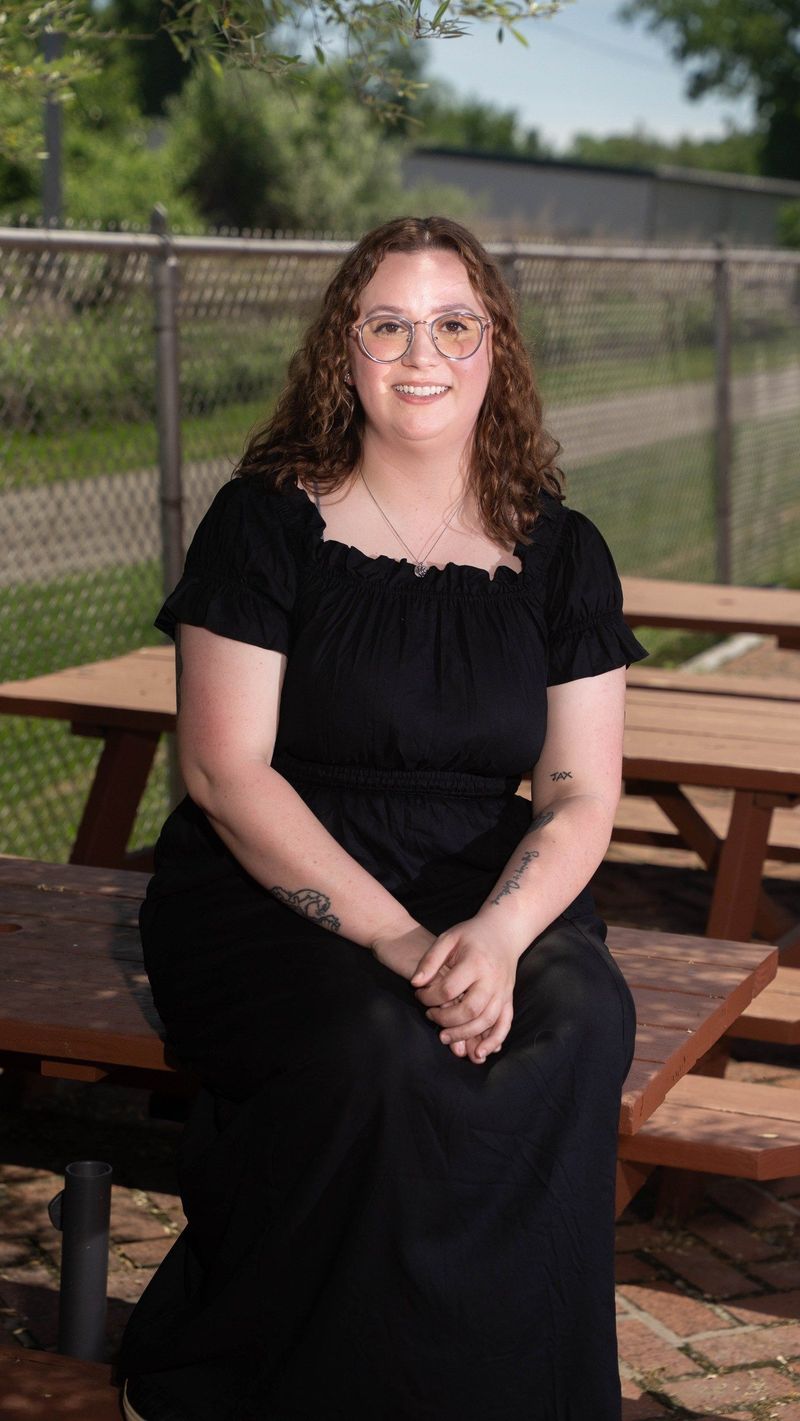 Seated outdoor portrait of the Brooke Team recruit smiling toward the camera