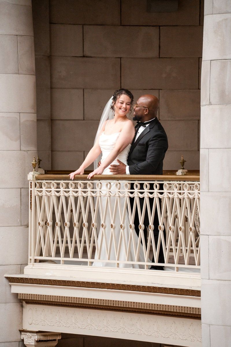 Christina and Tajay lean together on the upper balcony of Hartford City Hall