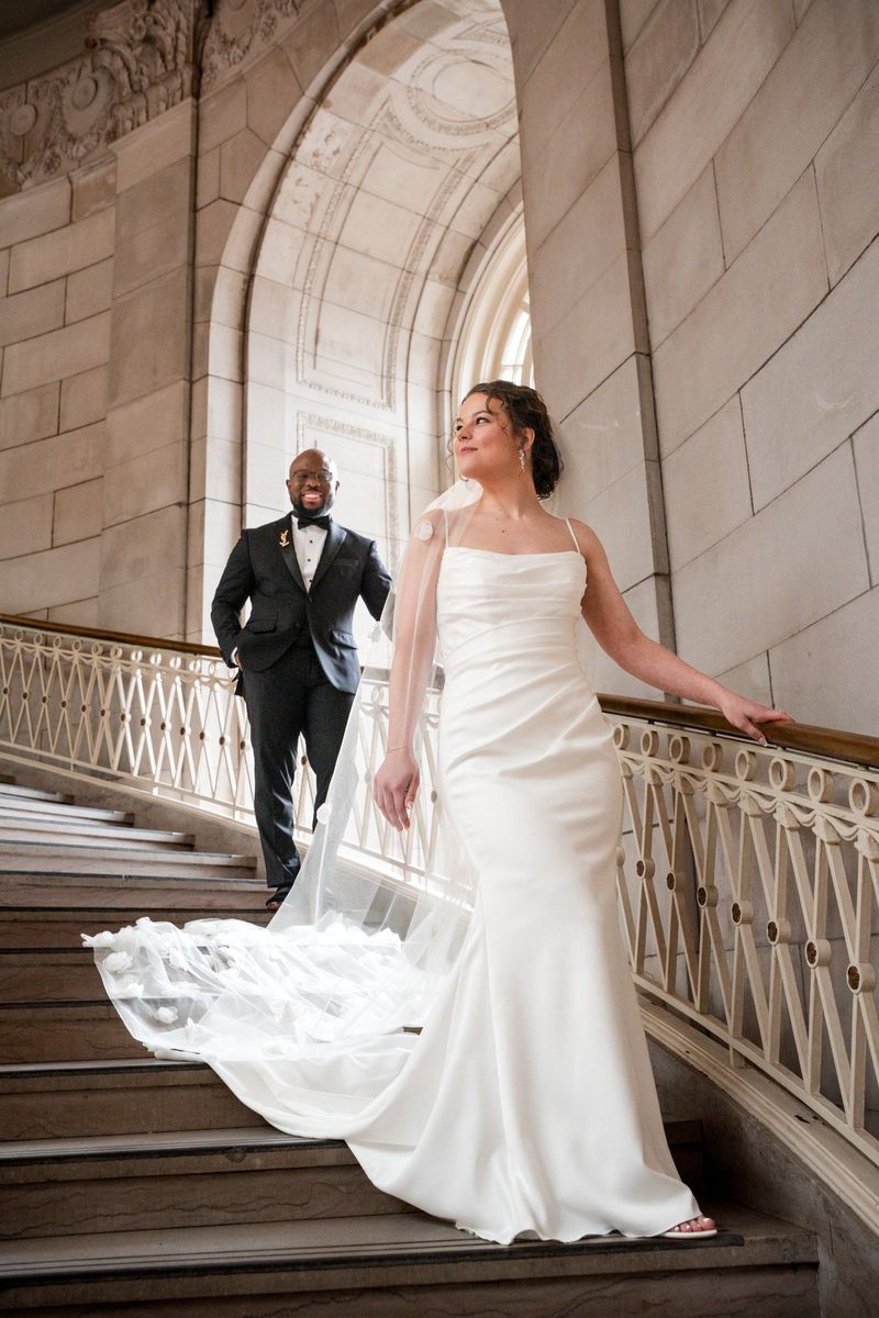 Christina stands in the foreground on the staircase with Tajay behind her