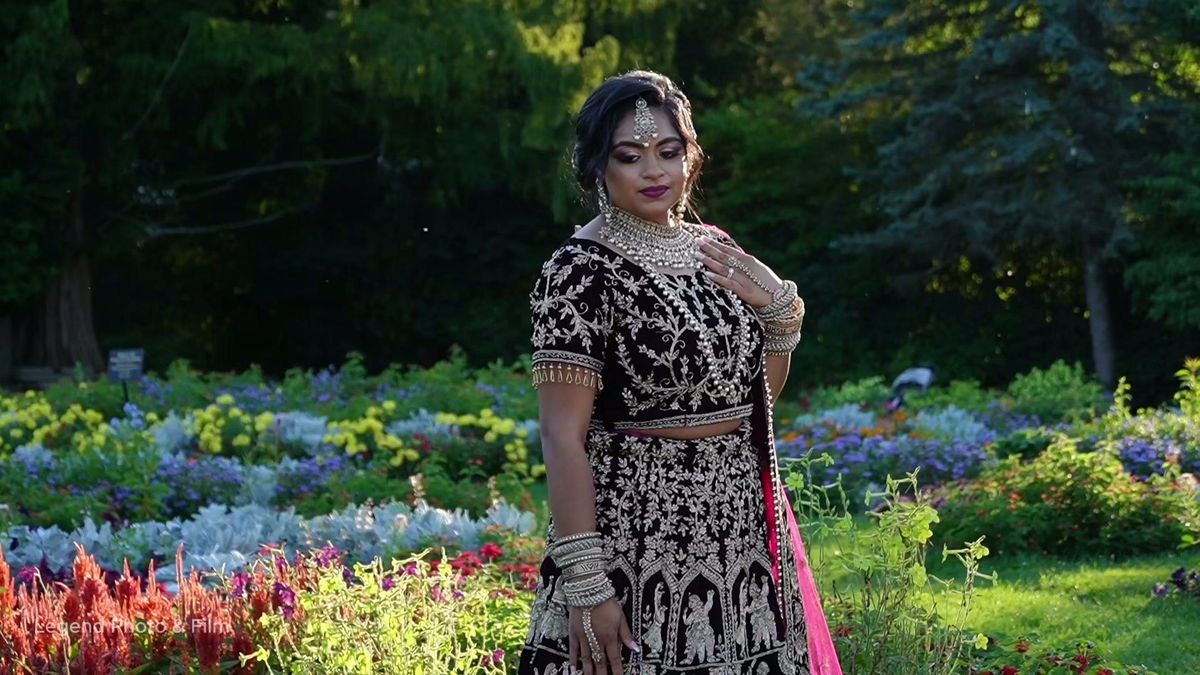 A close portrait of the woman in embroidered attire in the Elizabeth Park garden — video frame
