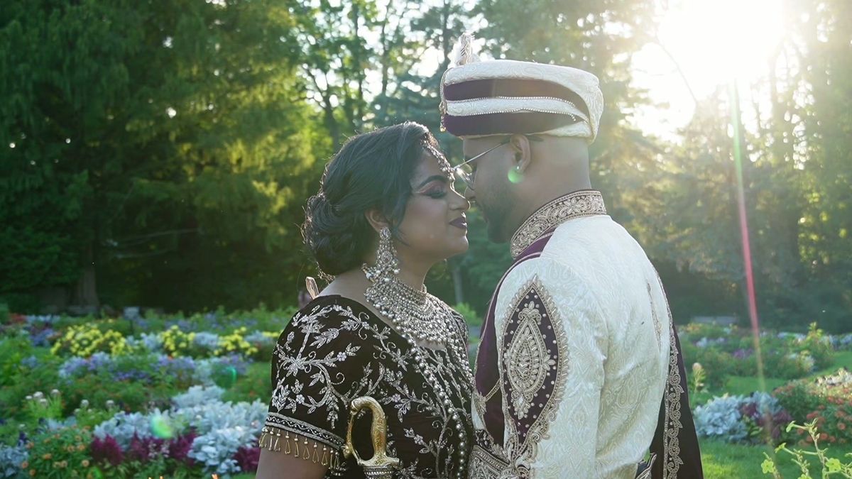 The couple share a close moment with sunlight behind the trees — video frame