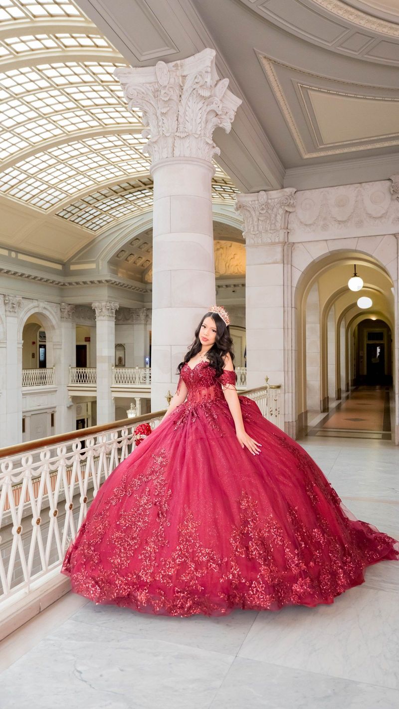 Genesis displays her burgundy gown beneath the glass atrium roof