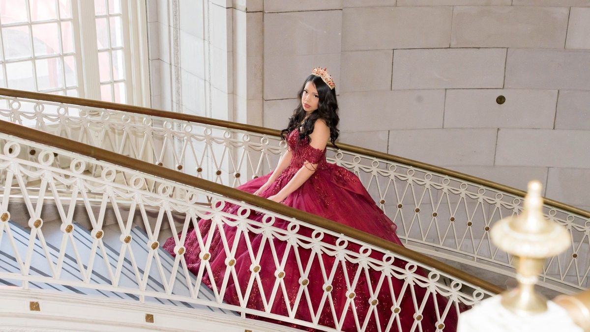 Genesis poses beside the white iron staircase railing