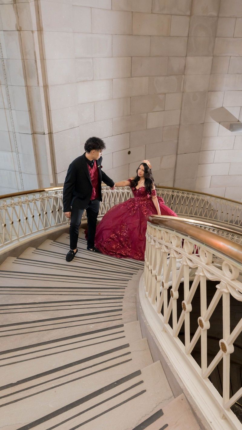 Genesis and a companion hold hands on the curved staircase