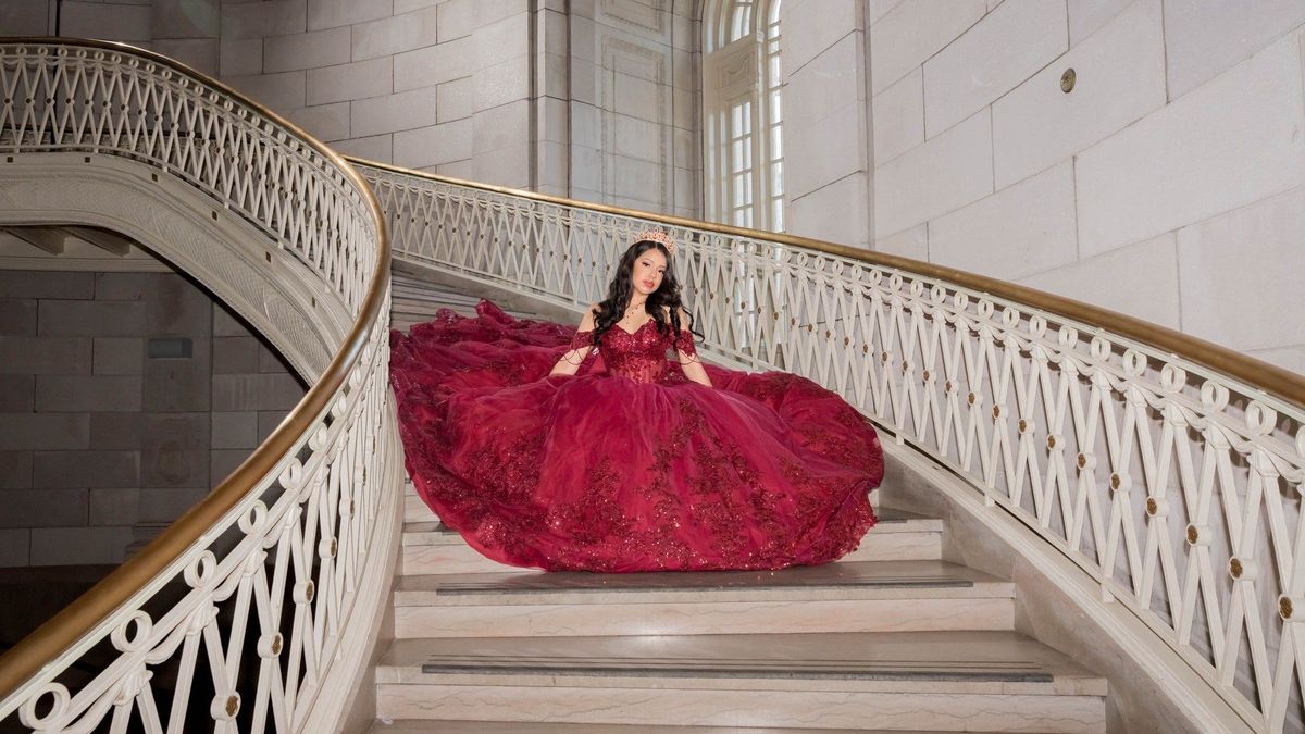 Genesis sits on the steps with her gown spread across the staircase