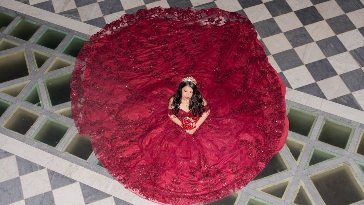 An overhead portrait shows Genesis with her gown spread in a circle on the patterned floor