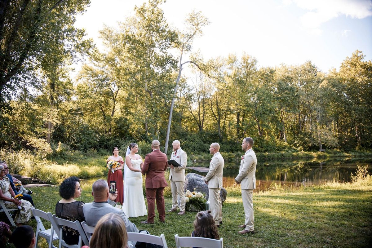 A wide view of Jacob and Thea’s ceremony beside the pond