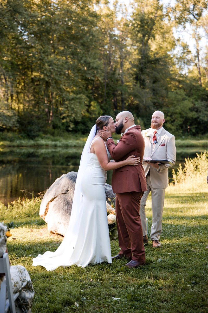 Jacob and Thea kiss beside the pond during their ceremony