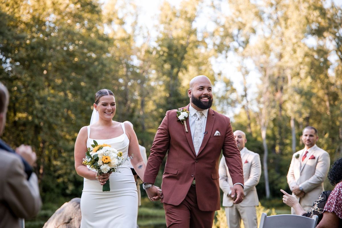 Jacob and Thea walk together down the aisle as guests applaud