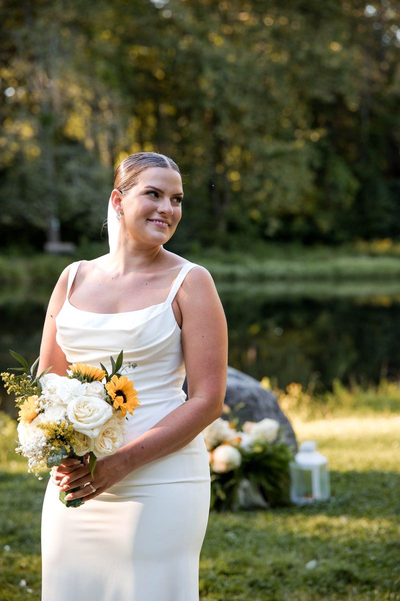Thea holds her bouquet in a closer portrait beside the pond