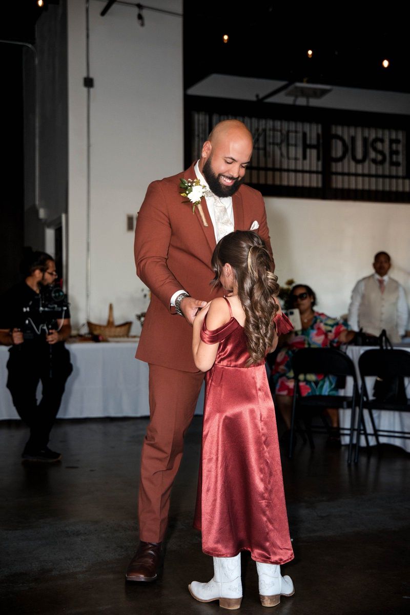 Jacob holds the hands of a young wedding party member on the dance floor