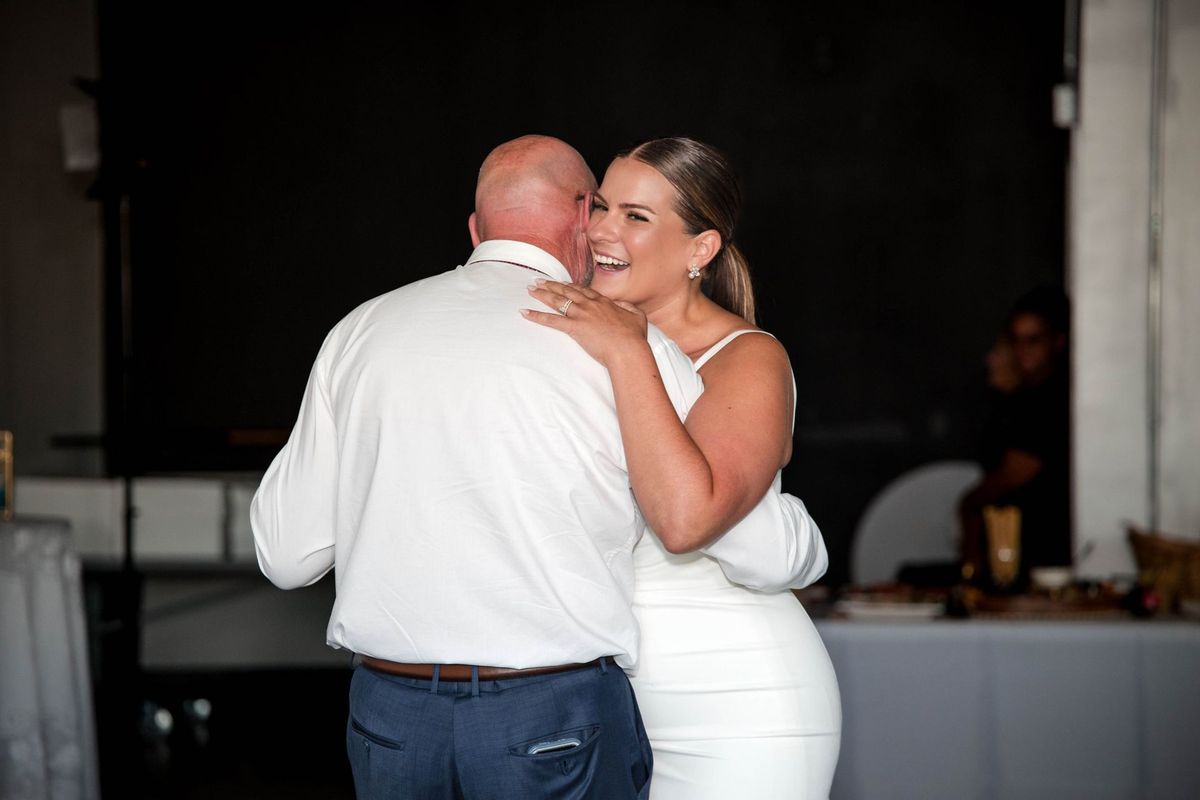 Thea smiles while dancing with a loved one in a white shirt