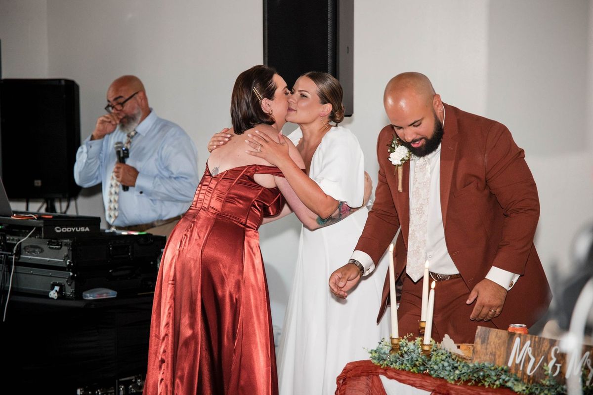 Thea embraces the speaker beside the sweetheart table