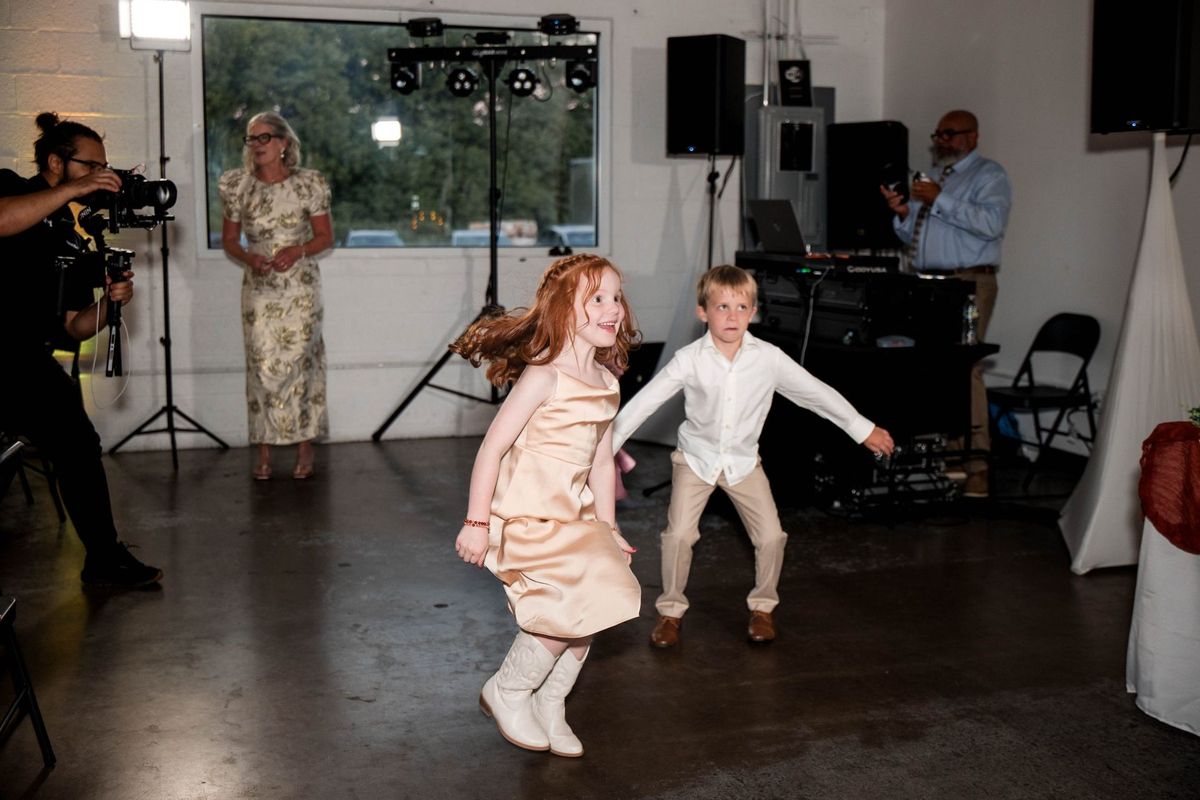 Young guests dance together inside the reception room