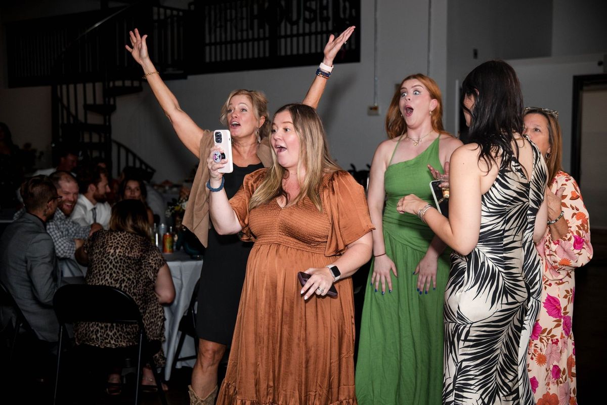 Guests raise their hands and cheer together on the dance floor