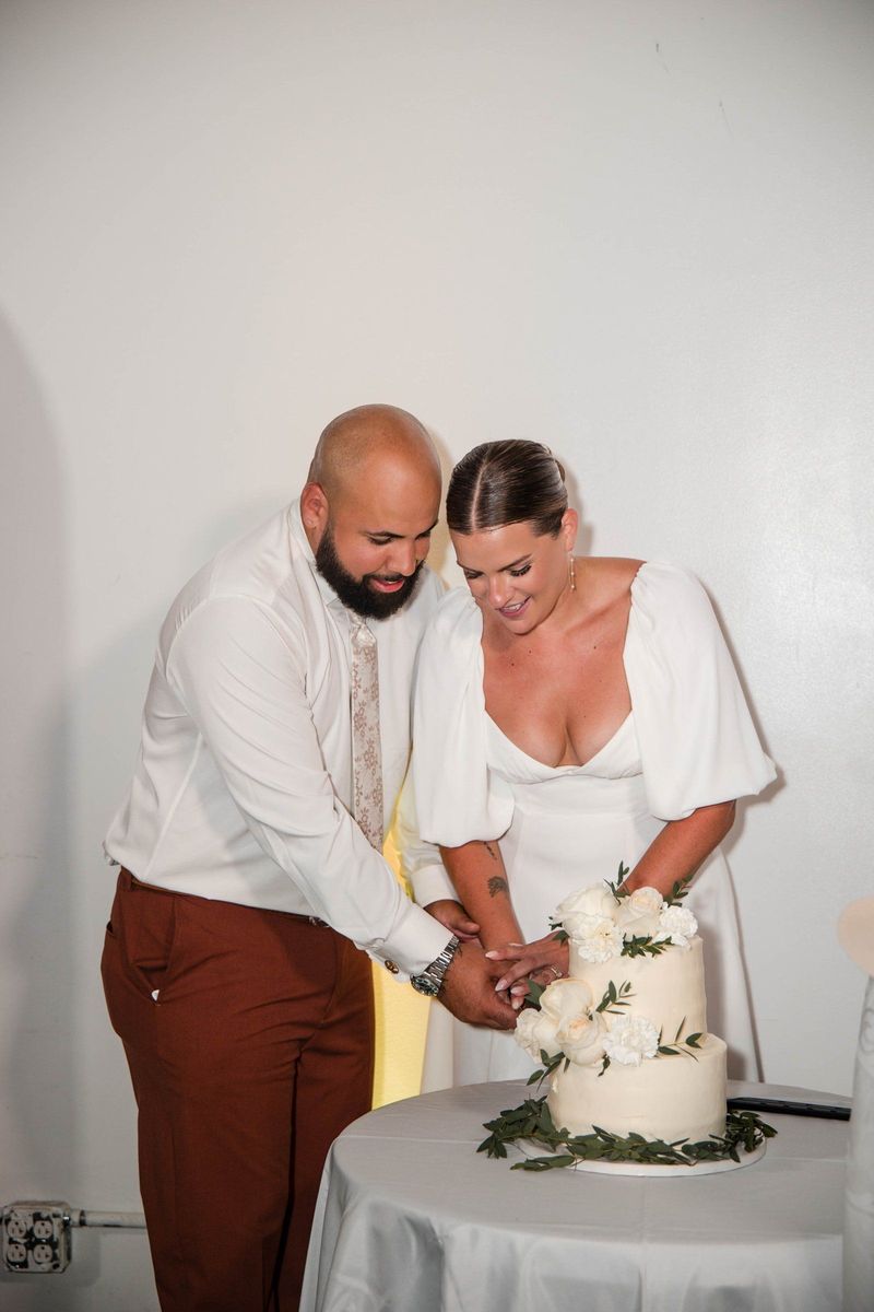 Jacob and Thea cut their flower-decorated wedding cake together