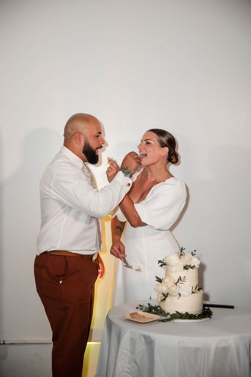 Jacob offers Thea a bite of cake beside the cake table