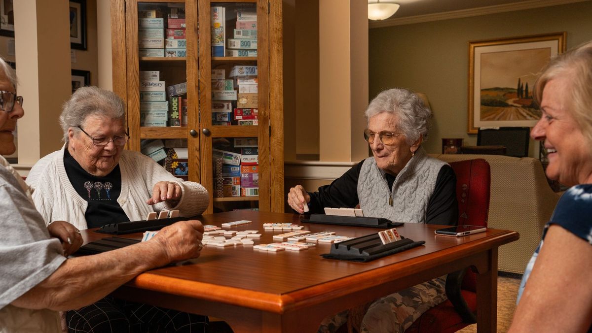 Group of people gathered around a tile game table at Jerome Home