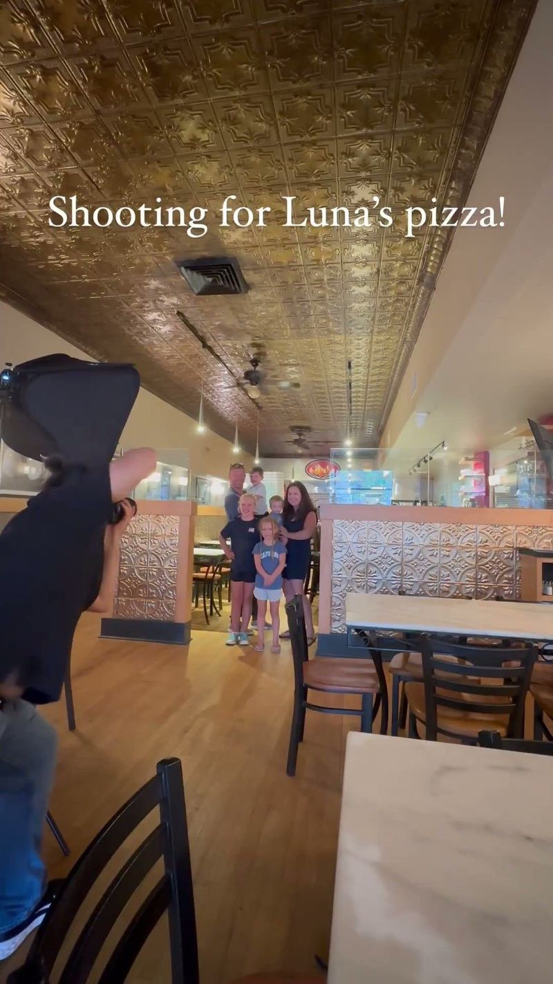 Behind the scenes at Luna's Pizza with a photographer making a group portrait in the dining room