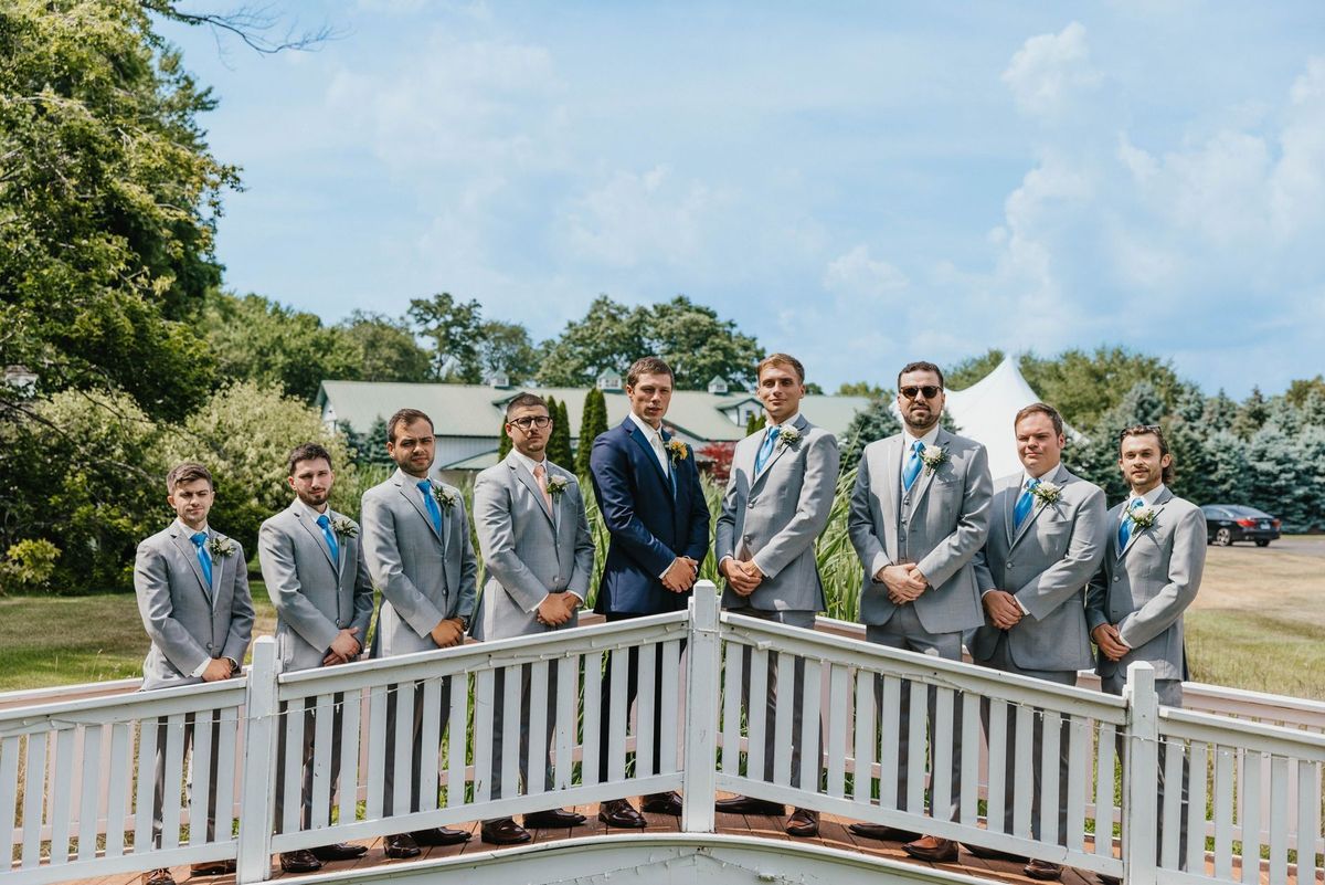 Max and the groomsmen arranged along a white bridge