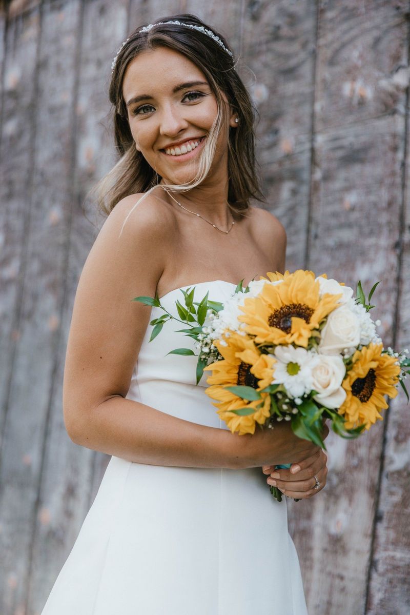 Mariana smiling with her sunflower bouquet