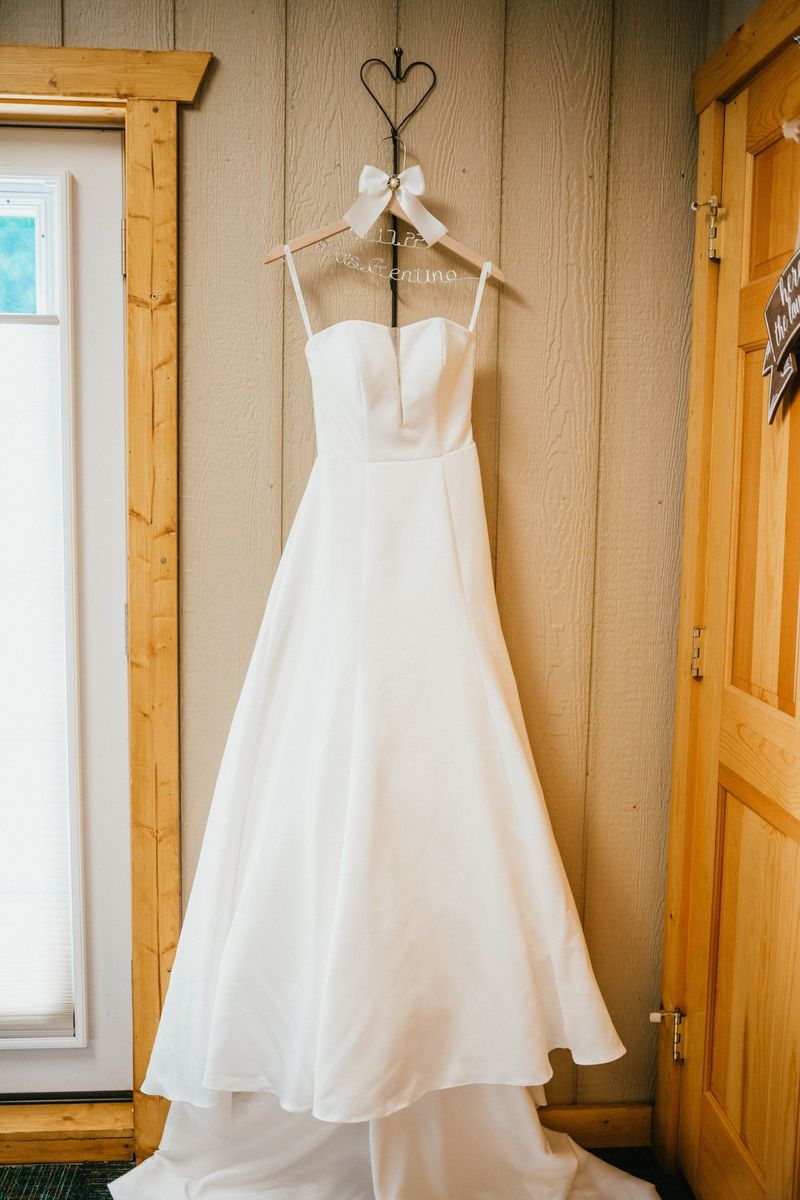 Wedding dress hanging beside a window