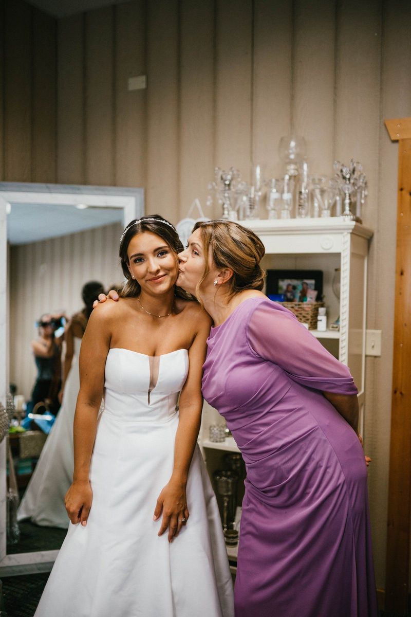 Mariana receiving a kiss on the cheek during preparations
