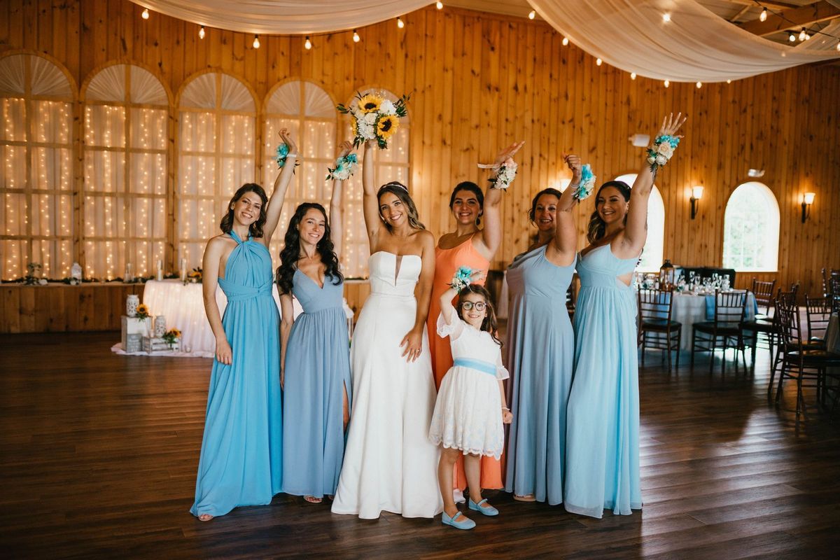 Bridal party raising their arms and bouquets
