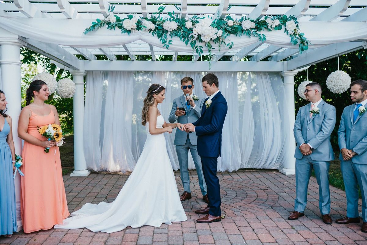Mariana and Max looking down toward their hands during the ceremony